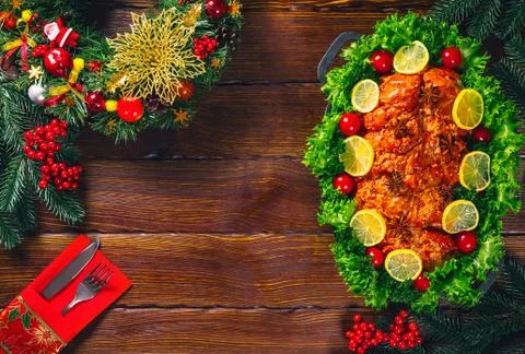 Christmas table dinner time with roasted meats decorated in Christmas style.  Stock Photos