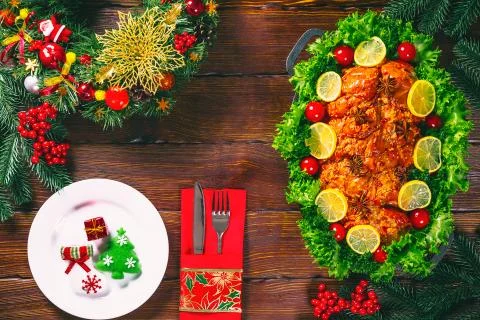 Christmas table dinner time with roasted meats decorated in Christmas style.  Stock Photos