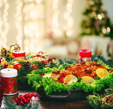 Christmas table dinner time with roasted meats decorated in New Year style on Stock Photos