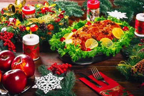 Christmas table dinner time with roasted meats decorated in Christmas style.  Stock Photos
