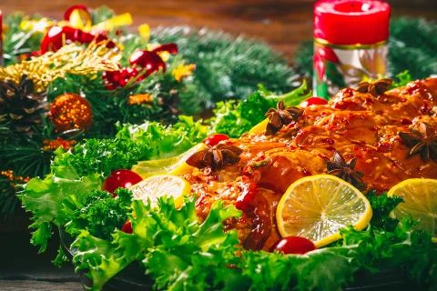 Christmas table dinner time with roasted meats decorated in Christmas style.  Stock Photos