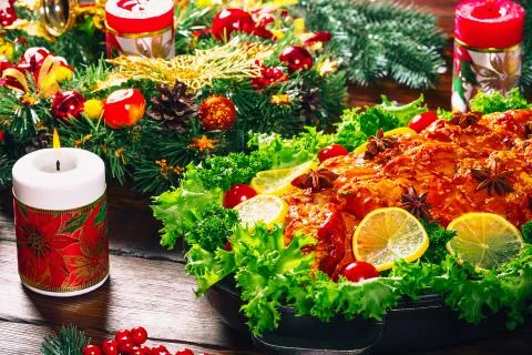 Christmas table dinner time with roasted meats decorated in Christmas style.  Stock Photos