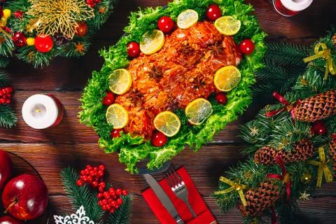 Christmas table dinner time with roasted meats decorated in Christmas style.  Stock Photos