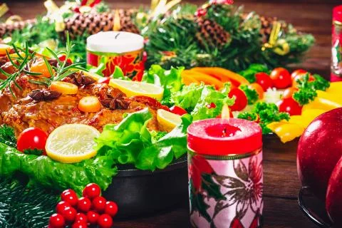 Christmas table dinner time with roasted meats, candles and New Year dcor. Ba Stock Photos