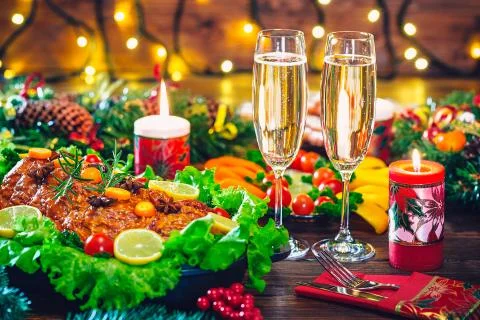 Christmas table dinner time with roasted meats decorated in Christmas style w Stock Photos