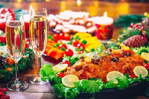 Christmas table dinner time with roasted meats decorated in Christmas style w Stock Photos