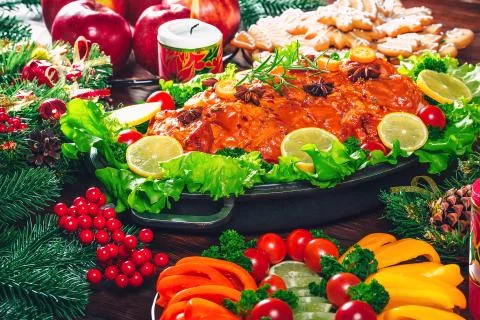 Christmas table dinner time with roasted meats, candles and New Year dcor. Ba Stock Photos