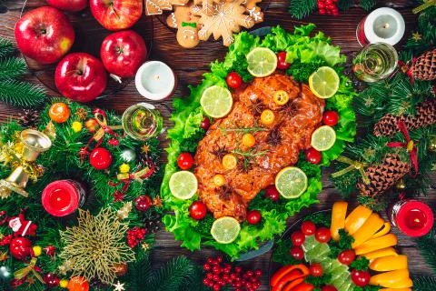 Christmas table dinner time with roasted meats, candles and New Year dcor. Ba Stock Photos