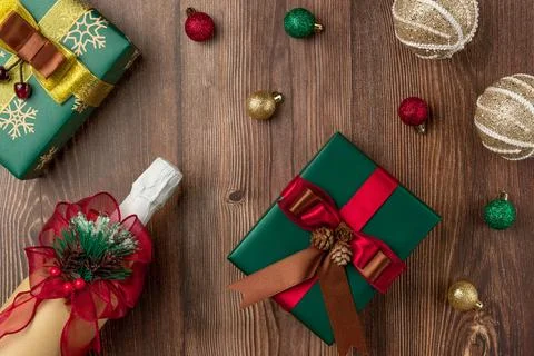 Christmas table with gift boxes and champagne bottle on wood background Stock Photos