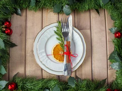 Christmas table layout, red tape with a cinnamon stick, rosmarin and a slice of Stock-Fotos
