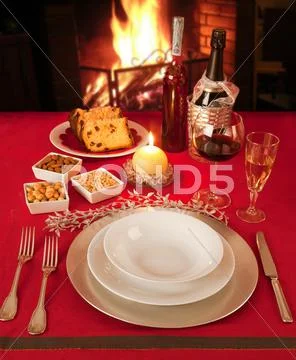 Christmas table near the fireplace, set for a single person. Stock Photos