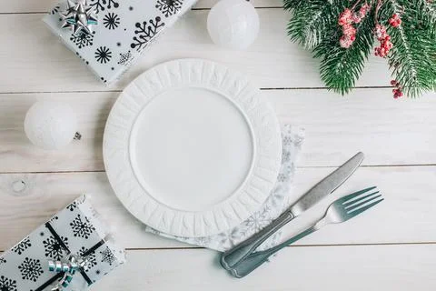 Christmas table place setting with empty plate and cutlery on white wooden .. Stock Photos