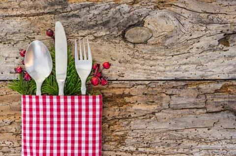 Christmas table place setting with rustic napkin on vintage wood background Stock Photos