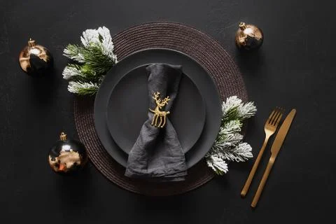 Christmas table setting with black plate and golden decorations on black ba.. Stock Photos