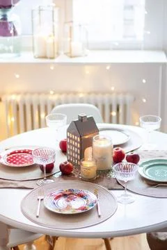 Christmas table setting with burning candles, retro lights and champagne gl.. Stock Photos