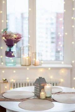 Christmas table setting with burning candles, retro lights and champagne gl.. Stock Photos