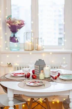 Christmas table setting with burning candles, retro lights and champagne gl.. Stock Photos