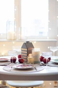 Christmas table setting with burning candles, retro lights and champagne glas Stock Photos