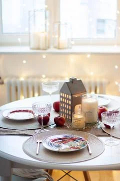 Christmas table setting with burning candles, retro lights and champagne glas Stock Photos