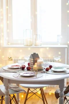 Christmas table setting with burning candles, retro lights and champagne glas Stock Photos