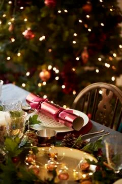 Christmas table setting a with Christmas cracker arranged on a plate and tabl Stockfoto's