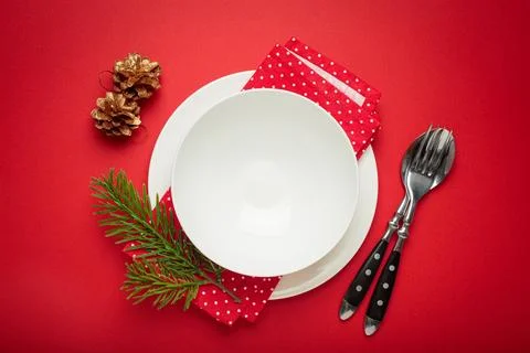 Christmas table setting decorated with pine cones and fir branches on red Stock Photos
