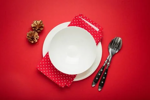 Christmas table setting decorated with pine cones and fir branches on red Foto stock