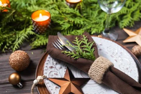 Christmas table setting with decorations, fir branches and candles. Stock Photos