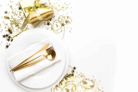 Christmas table setting with dishware, golden silverware on white backgroun.. Stock-Fotos