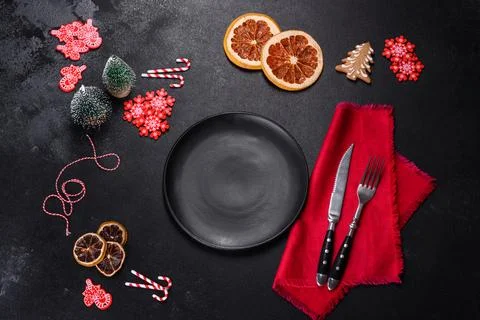 Christmas table setting with empty black ceramic plate, fir tree and black .. Stock Photos