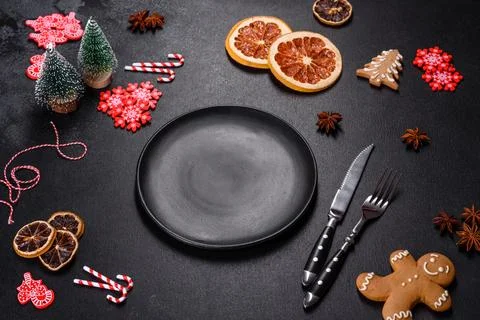 Christmas table setting with empty black ceramic plate, fir tree and black .. Stock Photos
