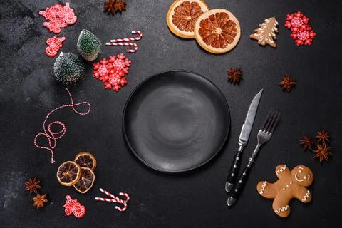 Christmas table setting with empty black ceramic plate, fir tree and black .. Stock Photos