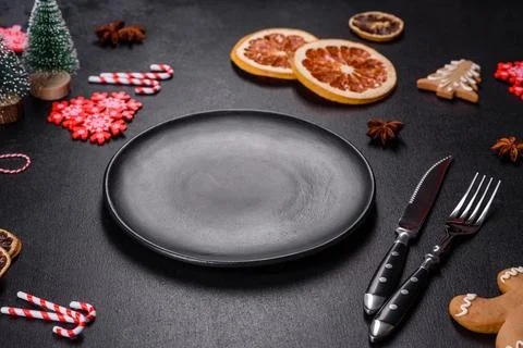 Christmas table setting with empty black ceramic plate, fir tree and black .. Stock Photos