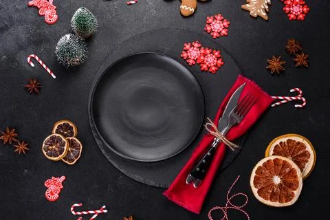 Christmas table setting with empty black ceramic plate, fir tree and black .. Stock Photos