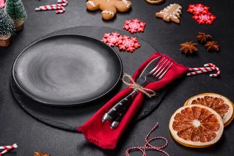 Christmas table setting with empty black ceramic plate, fir tree and black .. Stock Photos