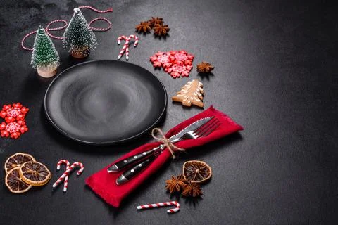 Christmas table setting with empty black ceramic plate, fir tree and black .. Stock Photos