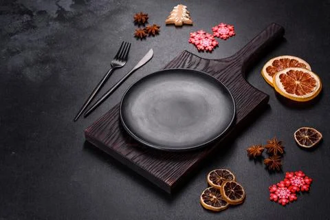 Christmas table setting with empty black ceramic plate, fir tree and black .. Stock Photos