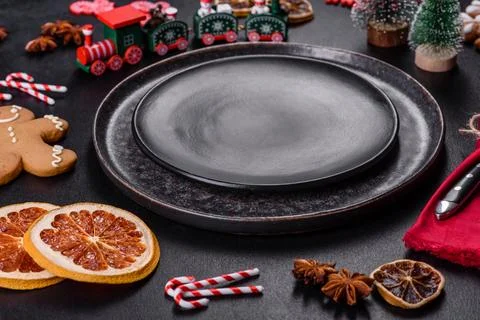 Christmas table setting with empty black ceramic plate, fir tree and black .. Stock Photos