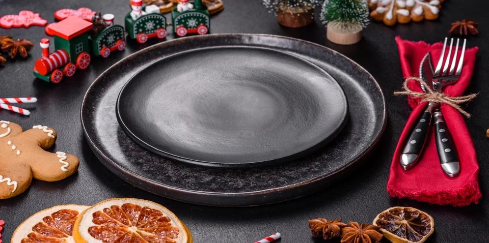 Christmas table setting with empty black ceramic plate, fir tree and black .. Stock Photos