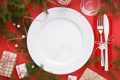 Christmas table setting with empty plate, cutlery and gift boxes Stock Photos