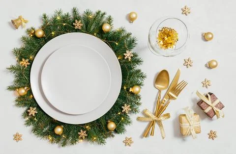 Christmas table setting with empty plate and gold accessories on white  Stock Photos