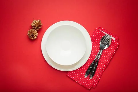 Christmas table setting with empty white plate and golden pine cones Stock Photos