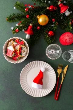 A Christmas table setting featuring an empty plate, napkin and gingerbread .. Stock Photos