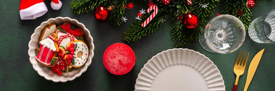 A Christmas table setting featuring an empty plate, napkin and gingerbread ,c Stock Photos