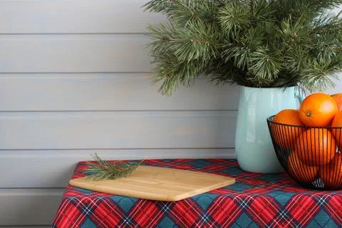 Christmas table setting featuring pine branches, oranges, and cutting board. New Stock Photos