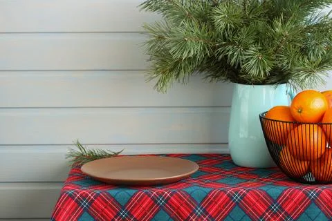 Christmas table setting featuring pine branches, oranges, and empty plate Stock Photos