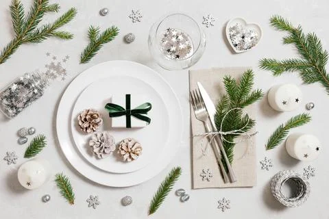 Christmas table setting with festive silver decorations, fir branches  Stock Photos