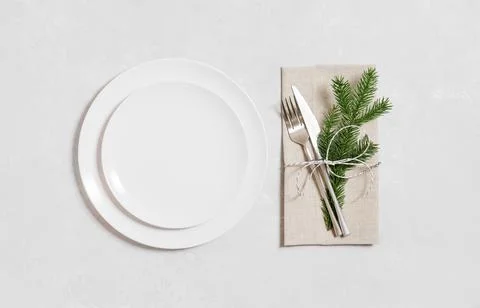 Christmas table setting on a gray background. Empty white plate for design. V Stock Photos