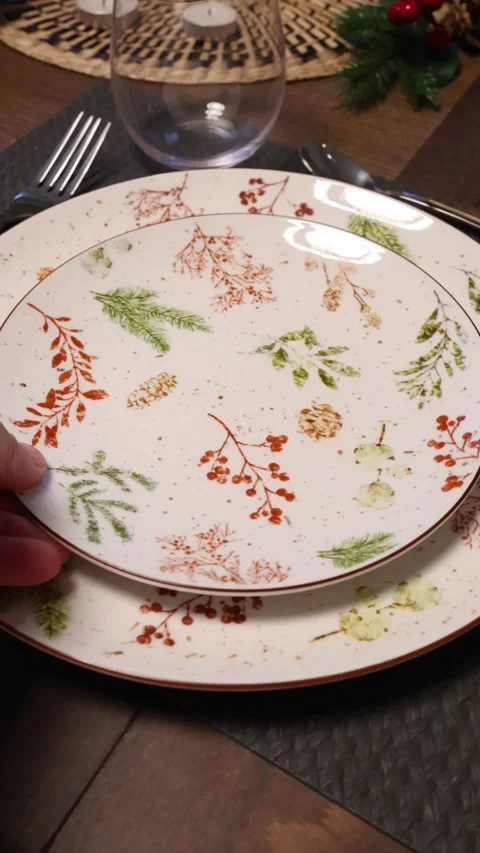 Christmas table setting. Modern plate with botanical pattern, glasses and Stock Footage 326503711