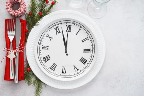 Christmas table setting with plate clock, napkin and cutlery. Stock Photos